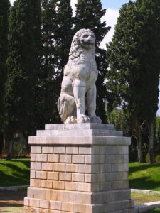 Tall square base supporting a lion sitting on its hindquarters