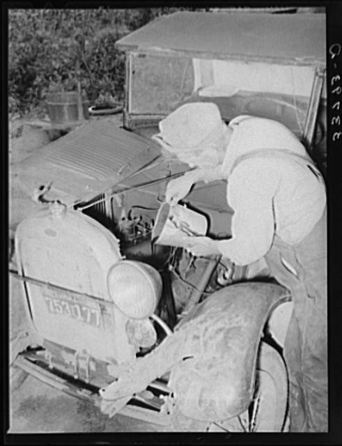 Elmer Thomas, migrant to California, pouring oil into engine preparatory for departure to California. Oklahoma.jpg