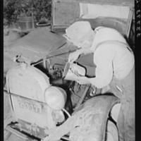Elmer Thomas, migrant to California, pouring oil into engine preparatory for departure to California. Oklahoma